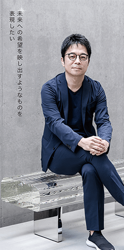 パリ・オルセー美術館にも展示されているガラスのベンチ Water Block（2002）に座る吉岡徳仁さん